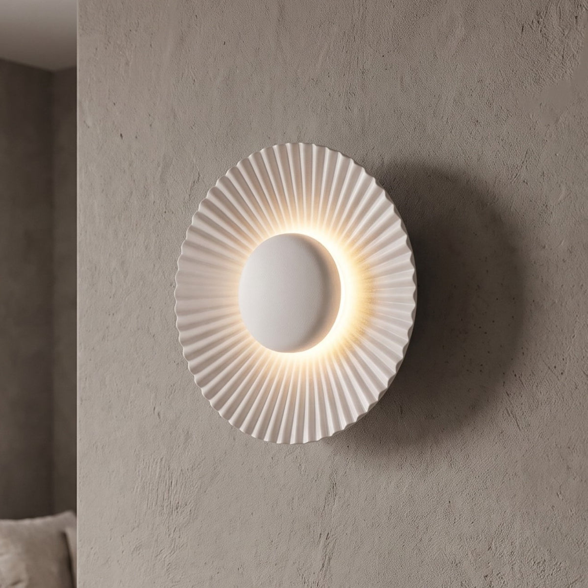 Applique murale LED moderne en aluminium blanc mat, 16 cm de diamètre, offrant une lumière chaleureuse et un design plissé élégant pour un salon.