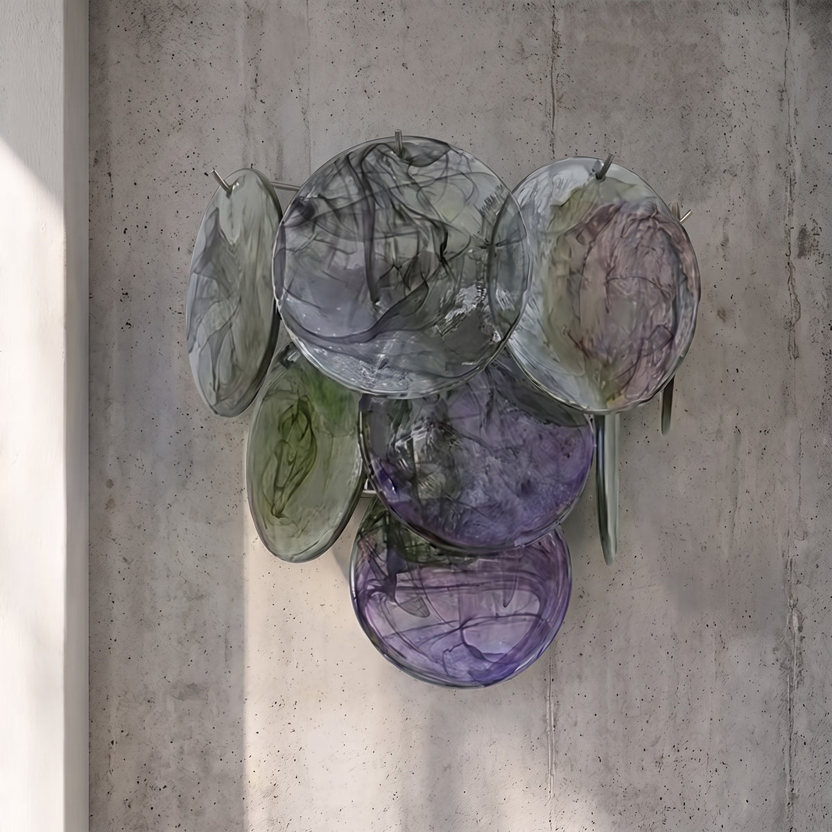 Composition artistique des disques de verre irisé de l'applique murale, avec des nuances changeantes de gris et d'ambre.