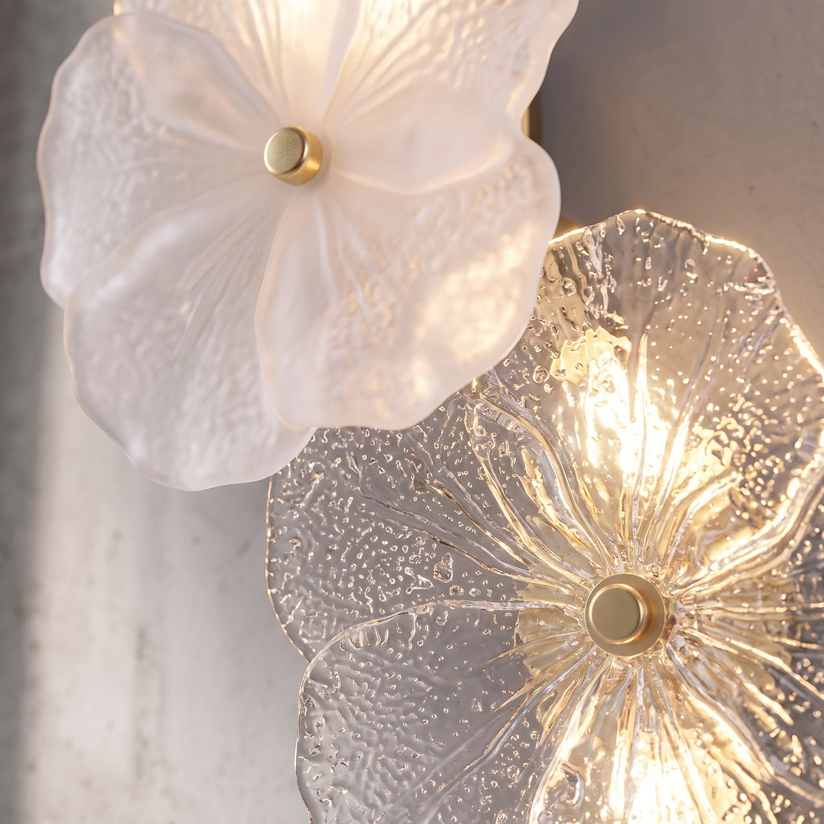 Détail rapproché des pétales de verre artisanal blanc opalin d'une fleur de l'applique, révélant la texture unique.