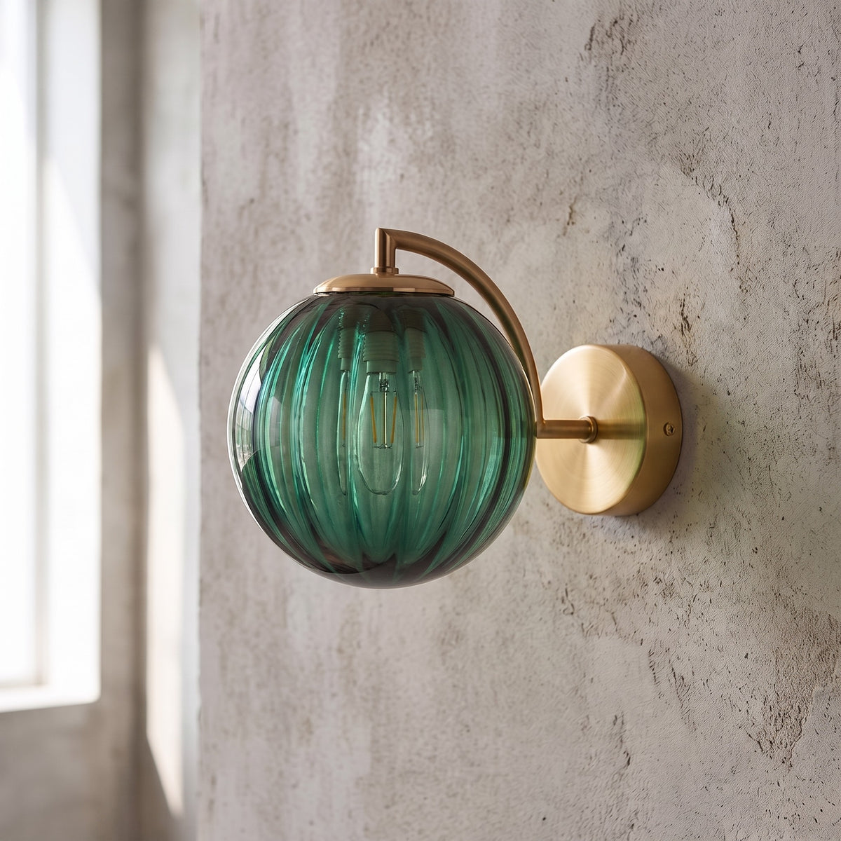 Profil de l'applique murale en verre vert émeraude, montrant l'harmonie entre le globe et le bras de support en laiton. (146)