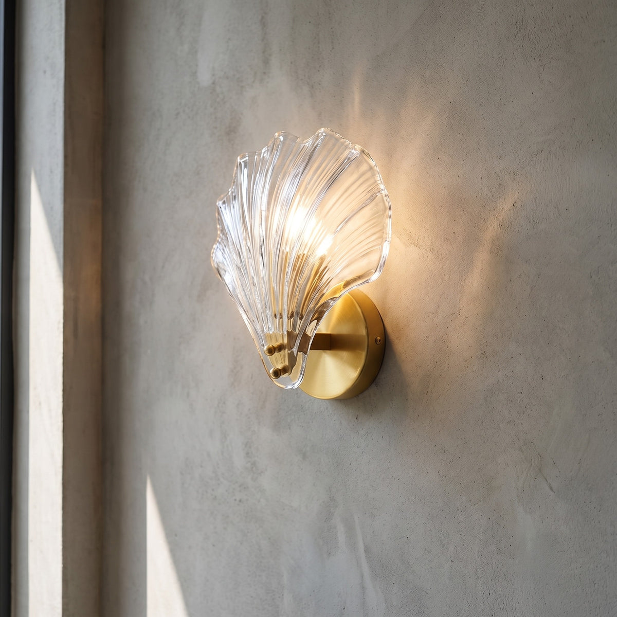 Applique murale moderne en verre nervuré en forme de coquillage, fixée sur un mur bleu profond, diffusant une lumière chaude et accueillante.