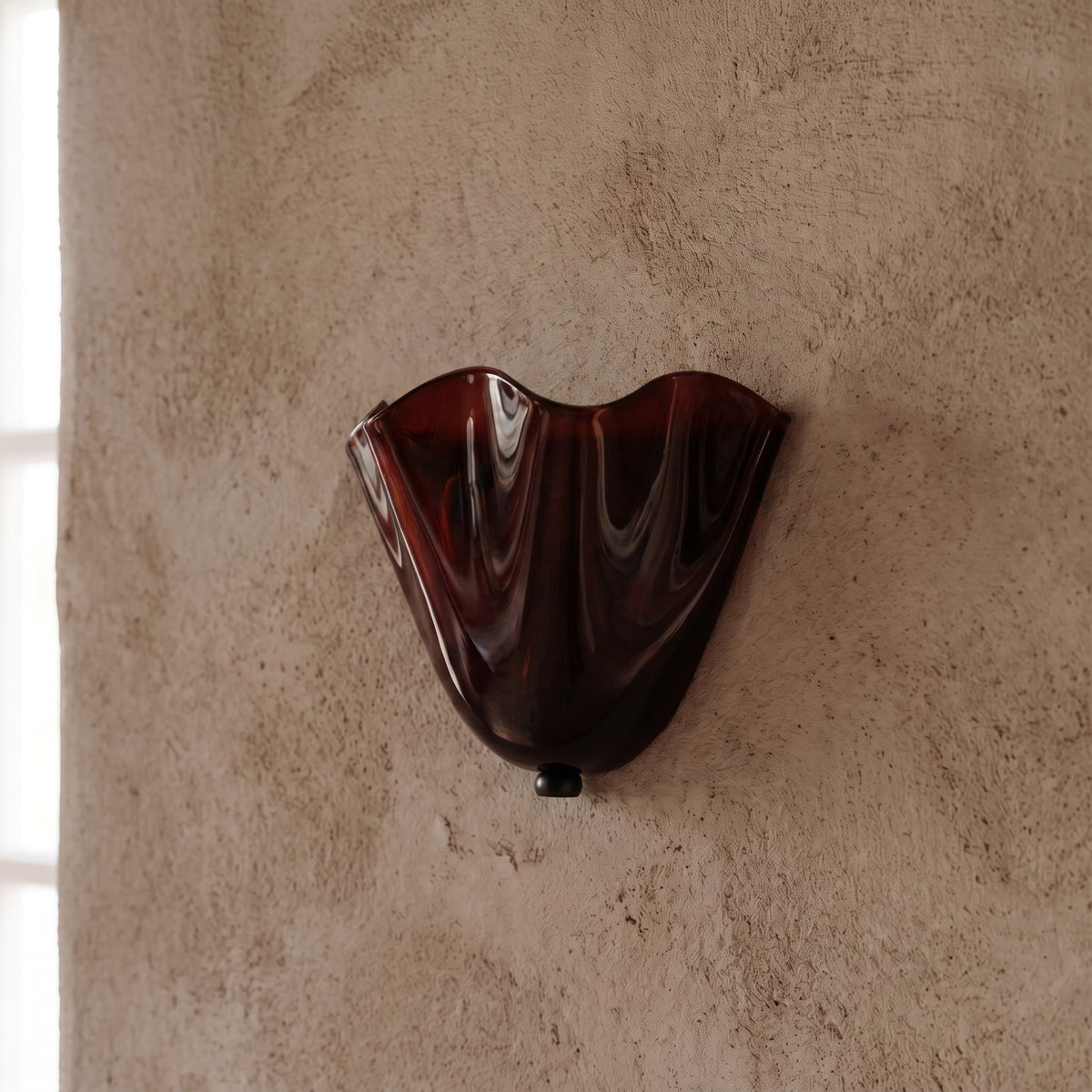 Lumière douce émanant de l'applique murale en verre ambré, idéale pour créer une ambiance relaxante dans une chambre à coucher.