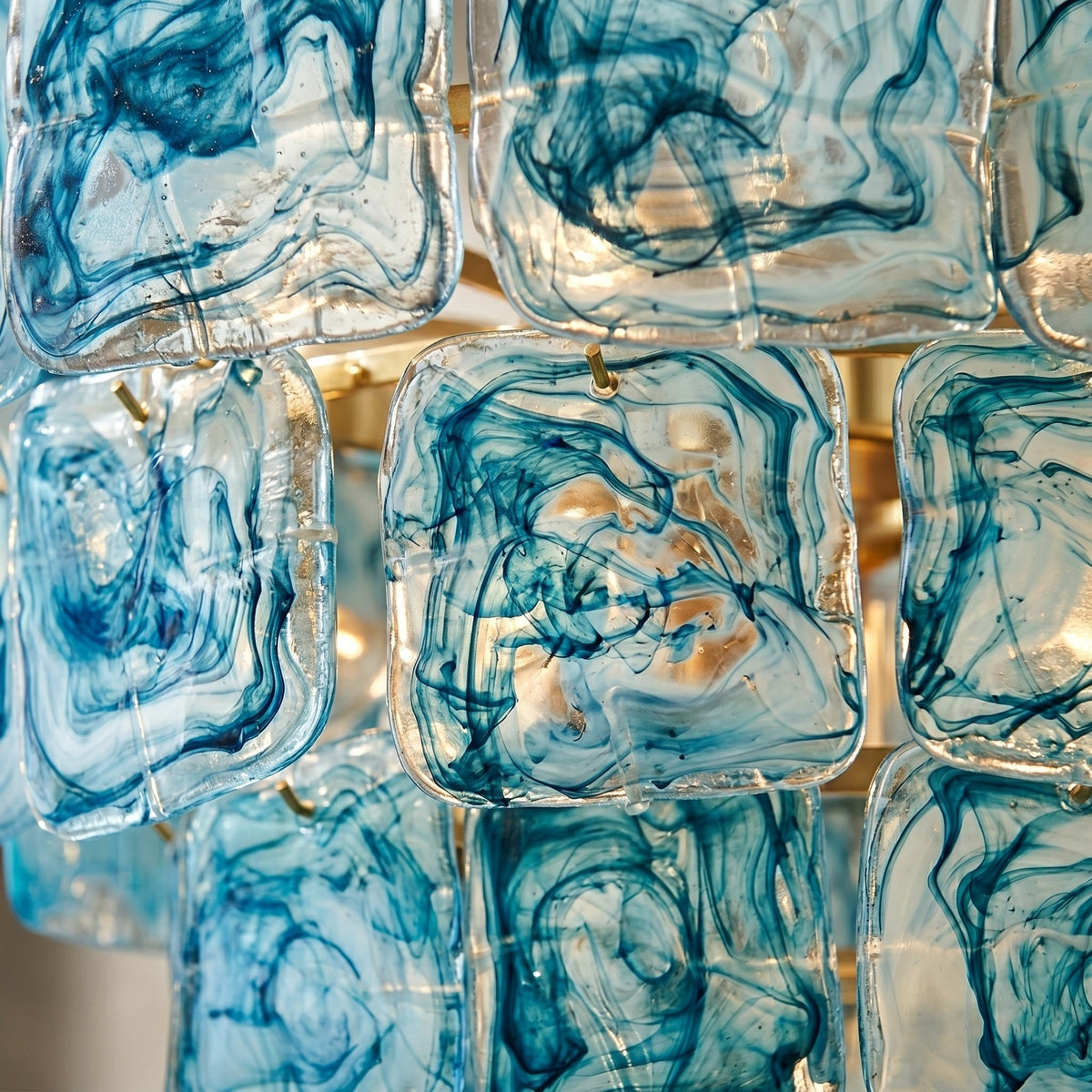 Lustre style Murano installé dans une salle à manger contemporaine, sa lumière douce met en valeur la table et l'ambiance chaleureuse.