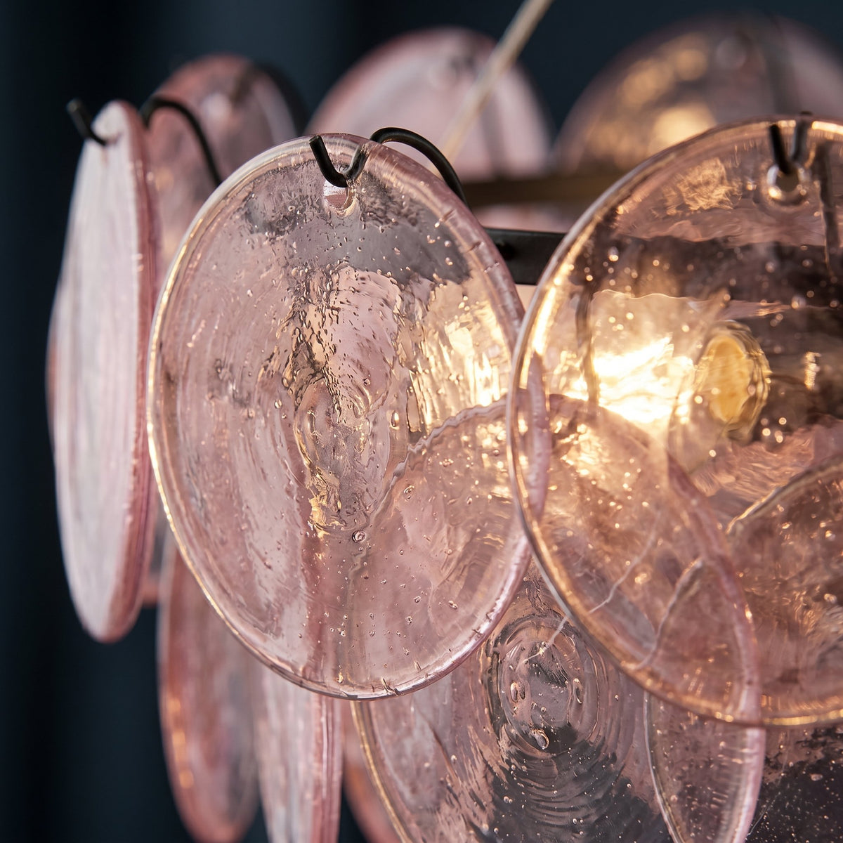 Détail du système de fixation au plafond et du câble de suspension ajustable de 120 cm sur un lustre en verre rose.