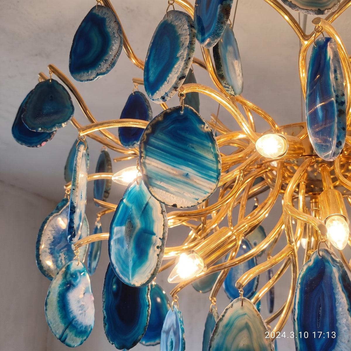 Lustre Art Déco avec ses 12 ampoules LED G9 allumées, créant un éclairage doux et diffus dans une pièce de vie.