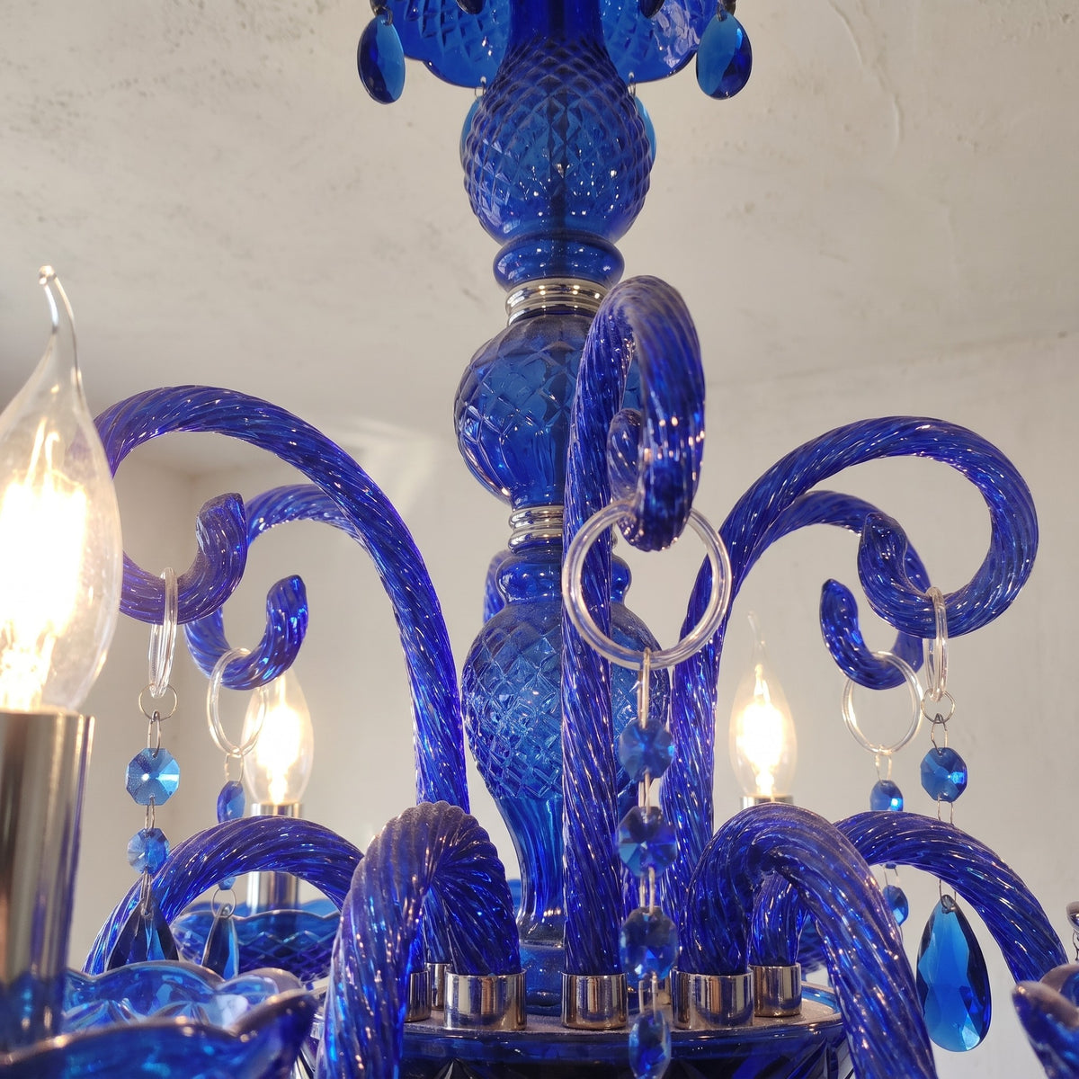 Lustre de 65 cm de diamètre et 65 cm de hauteur, pièce maîtresse suspendue dans une salle à manger lumineuse.