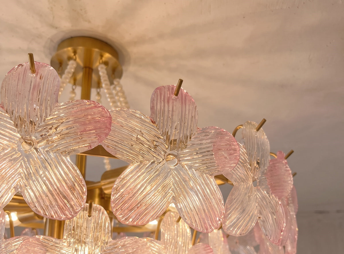 Lustre floral allumé, diffusant une lumière chaude et accueillante dans une chambre à coucher, créant une ambiance cosy et apaisante.