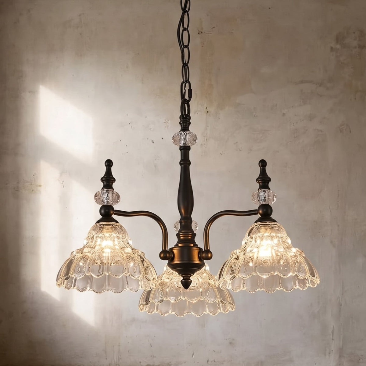 Vue d'ensemble du lustre style Murano suspendu, mettant en valeur ses trois lumières et son élégante finition bronze antique dans un salon.