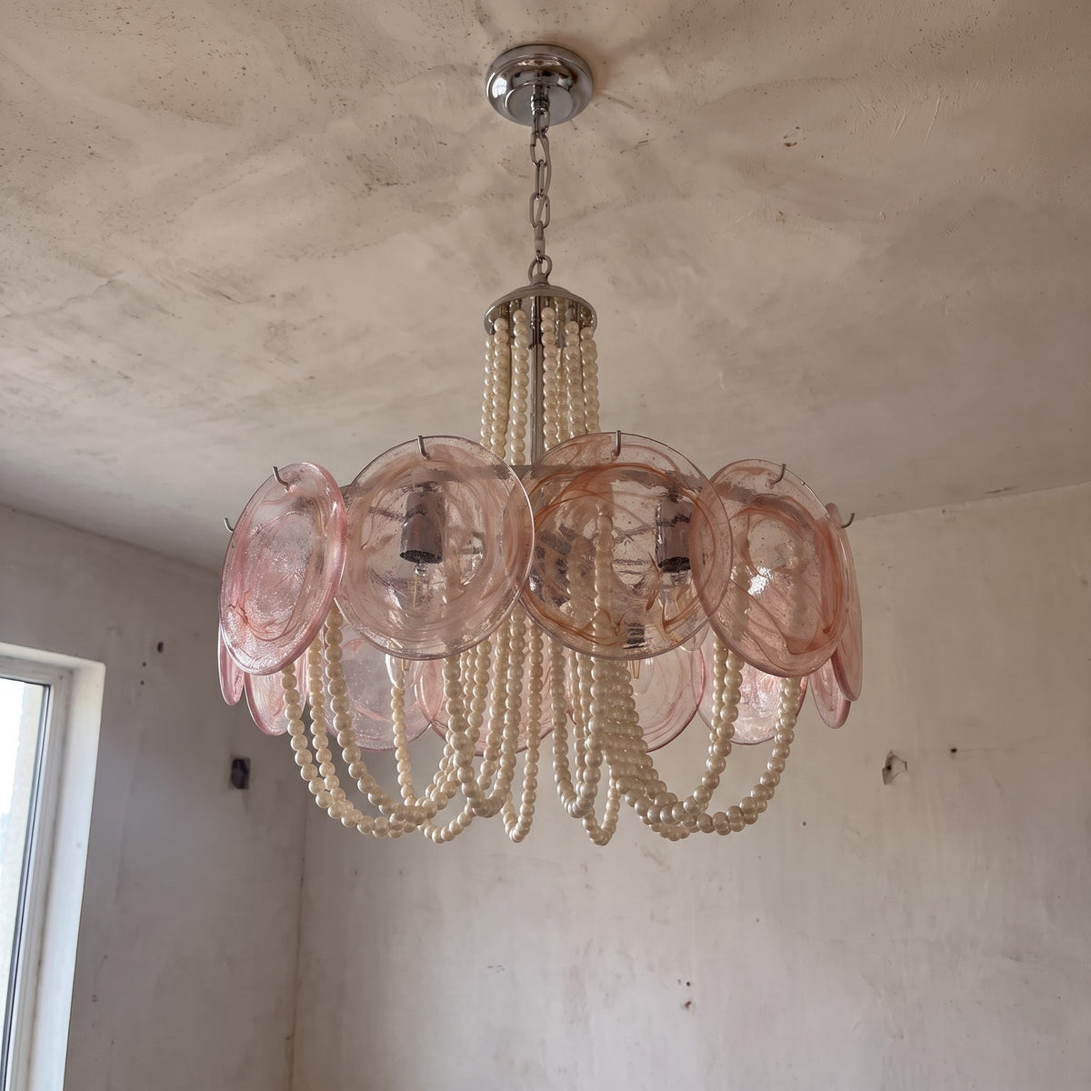 Le lustre rose et perles en situation, offrant une perspective sur sa taille (60,5x50cm) et son impact visuel dans la pièce.
