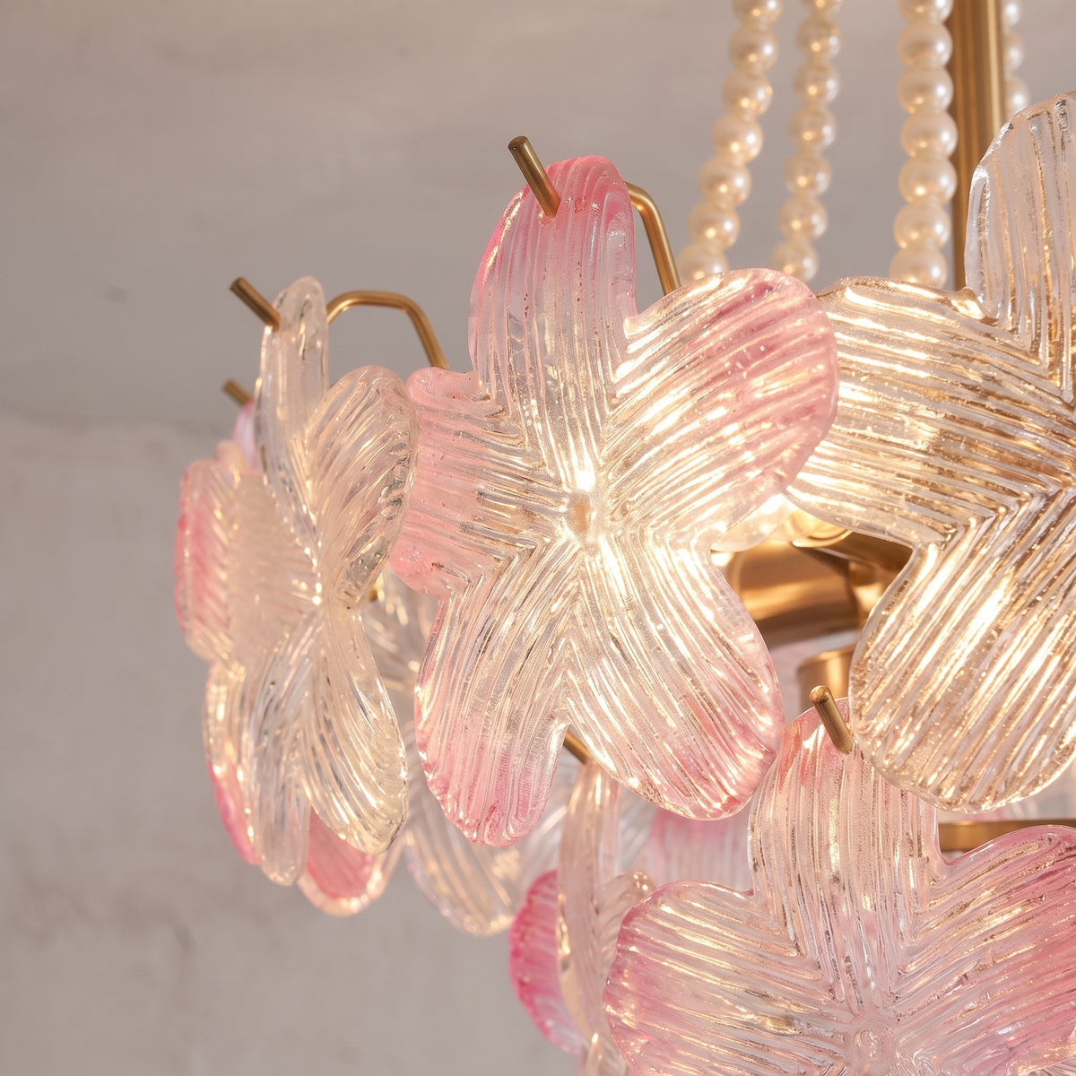 Le lustre style Murano rose vu de côté, montrant sa structure en fer doré et la disposition harmonieuse des 40 cm de diamètre de ses pétales de verre.