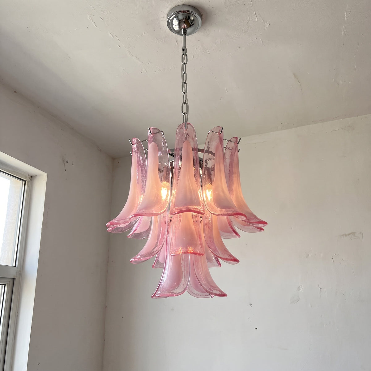 Vue d'ensemble du lustre suspension Pétales Roses, verre soufflé rose et structure chromée, idéal pour un salon moderne et élégant.