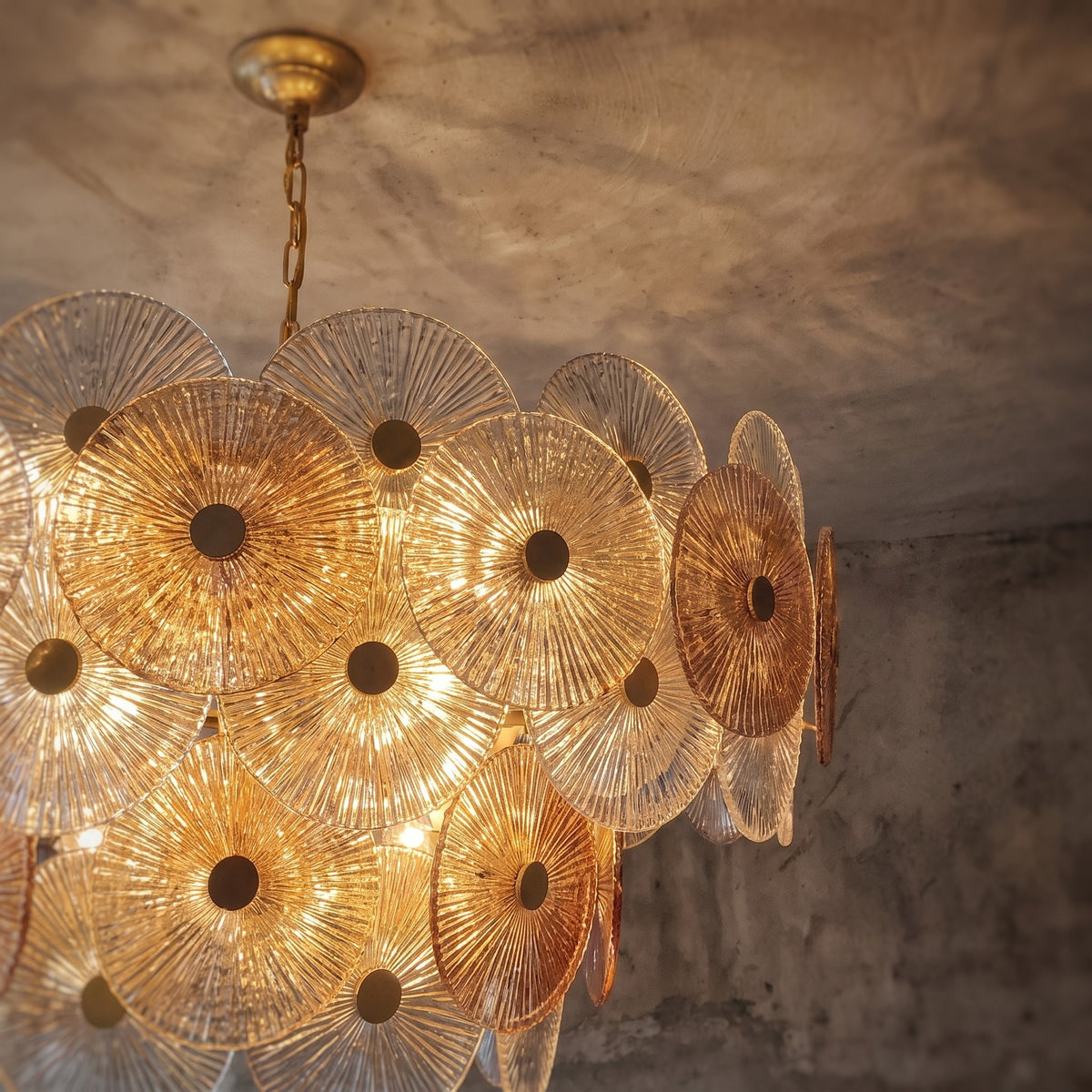 Lustre style Murano allumé, diffusant une lumière chaude et accueillante, idéal pour un salon ou une salle à manger raffinée.