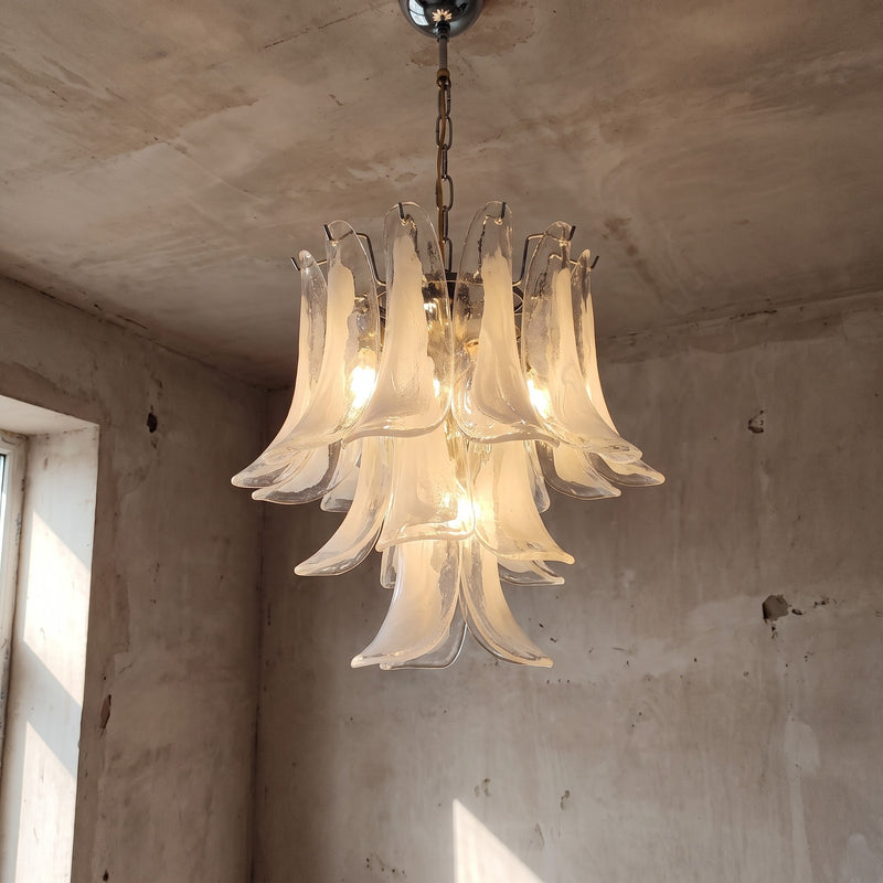 Lustre style Murano en verre blanc opalin, forme de fleur, suspendu dans un salon moderne, éclairage doux et élégant.