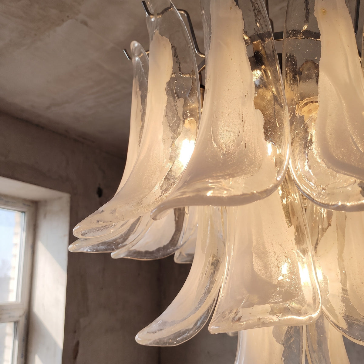 Lustre allumé révélant la chaleur de ses ampoules LED, créant une ambiance accueillante dans une pièce de vie.