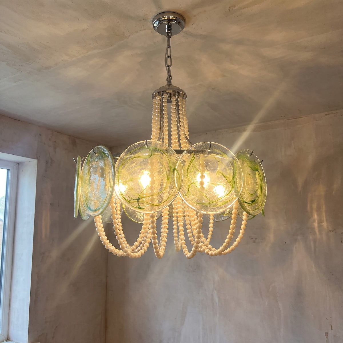 Vue d'ensemble du lustre rond style Murano, avec ses disques de verre vert clair ambré et ses élégantes perles crème.