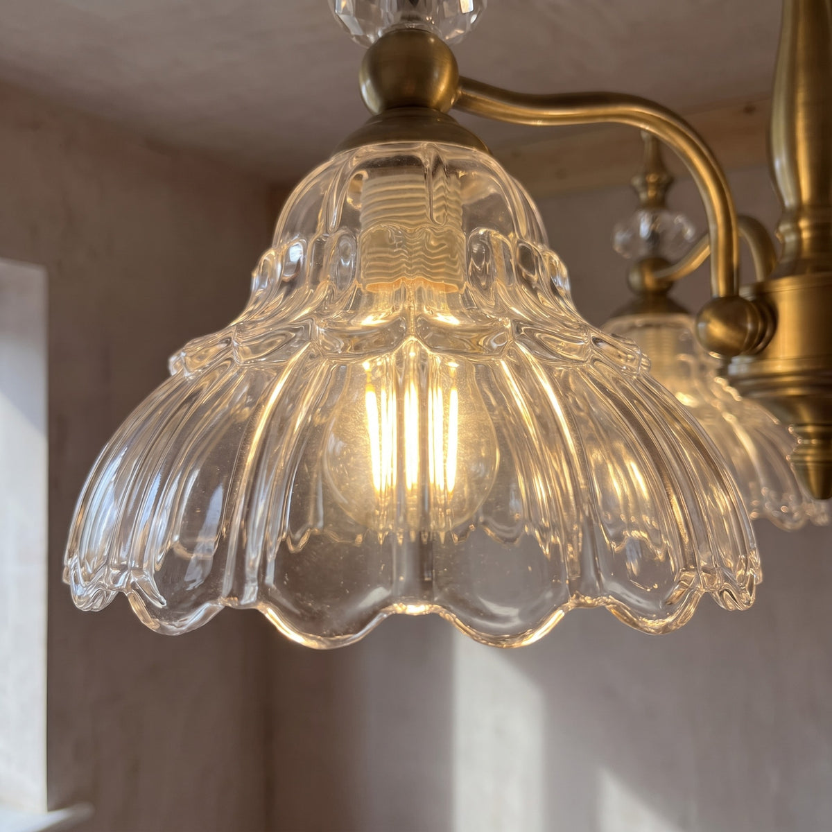 Suspension luminaire en bronze antique, montrant la finition détaillée du métal et la robustesse de sa chaîne de fixation.