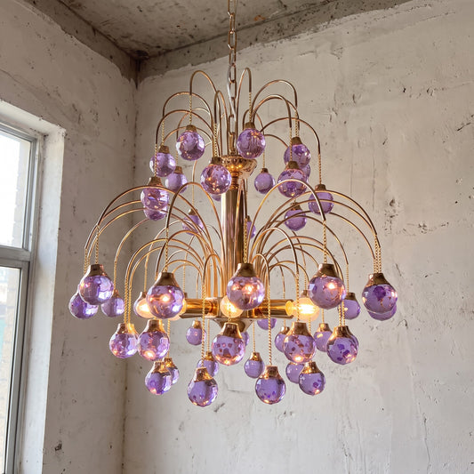 Lustre style Murano violet lavande, vue d'ensemble, illuminant un salon moderne avec une lumière douce et chaleureuse.
