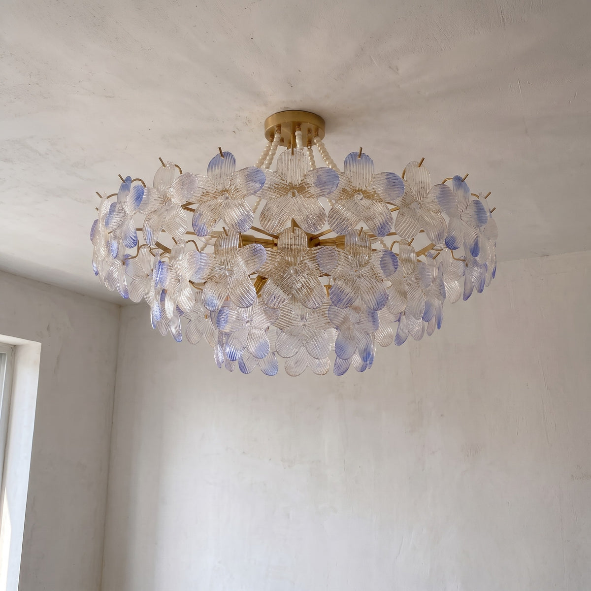 Photographie d'ensemble du lustre plafonnier style Murano, montrant sa structure métallique dorée et ses multiples couches de pétales de verre irisé.