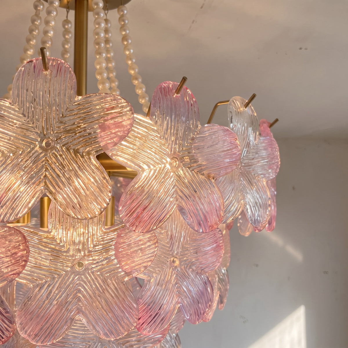Lustre suspendu au plafond, révélant ses six douilles E14 pour ampoules LED, créant une ambiance lumineuse et raffinée.