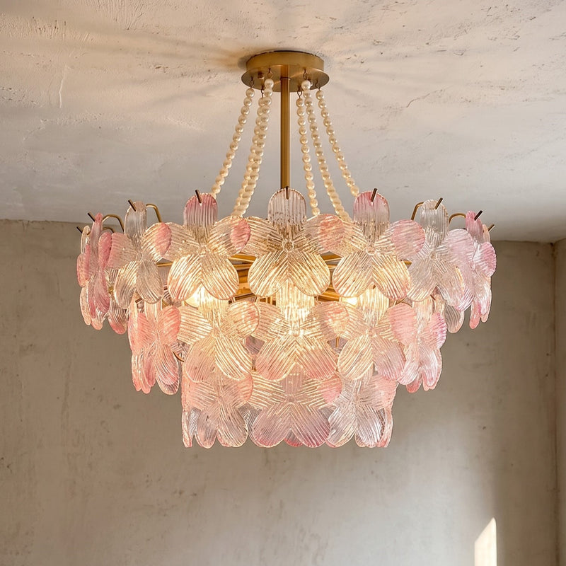 Lustre rose à pétales de verre style Murano, suspension florale éclairant un salon moderne avec élégance et douceur.