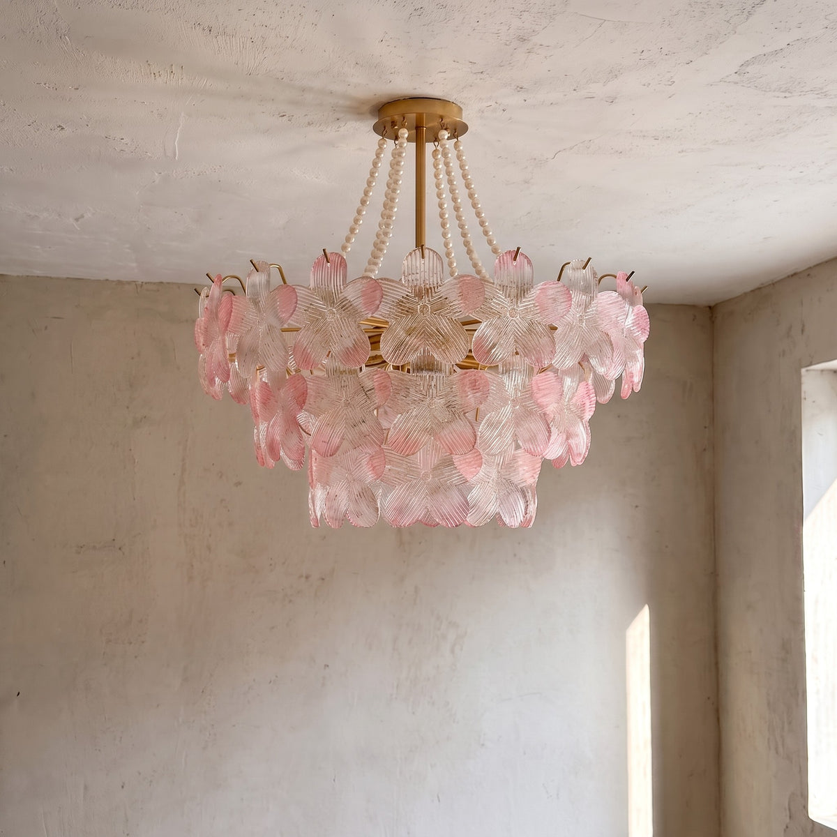 Vue rapprochée des pétales de verre rose translucide du lustre, reflétant la lumière avec un éclat délicat et chaleureux.