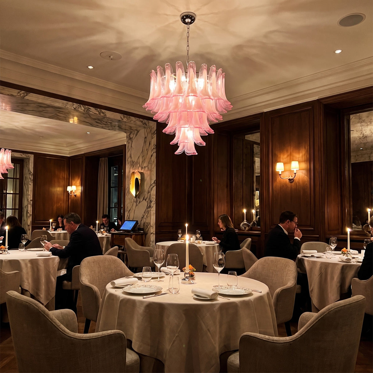 Image d'un lustre à pétales de verre rose installé au plafond, créant un point focal artistique dans un intérieur lumineux.