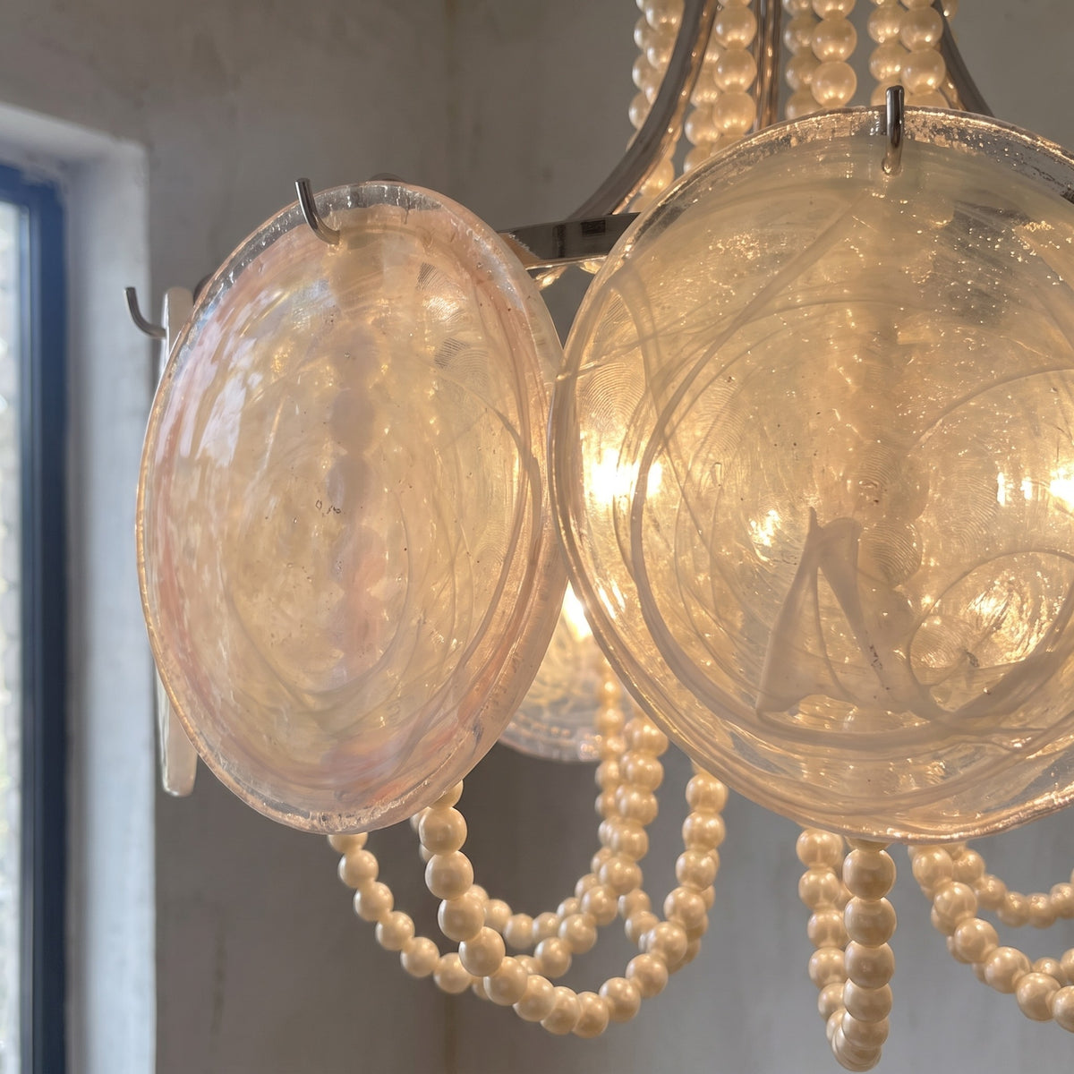 Le lustre suspendu dans un intérieur moderne, créant une ambiance lumineuse chaleureuse pour un salon ou une chambre chic.