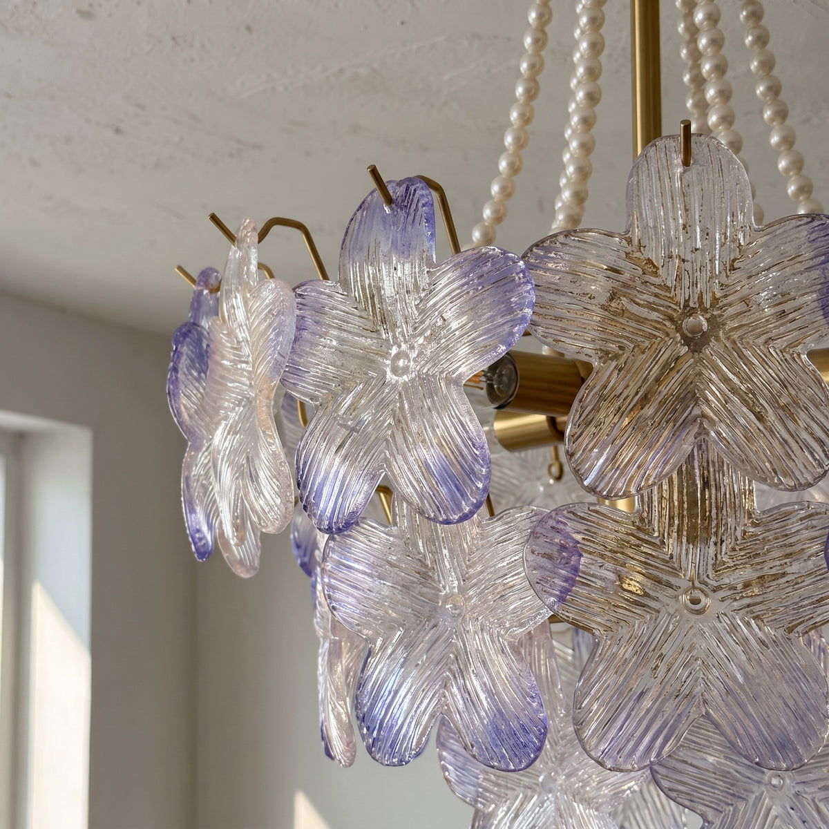 Lustre allumé, diffusant une lumière douce et chaleureuse, créant une atmosphère accueillante dans une chambre à coucher.