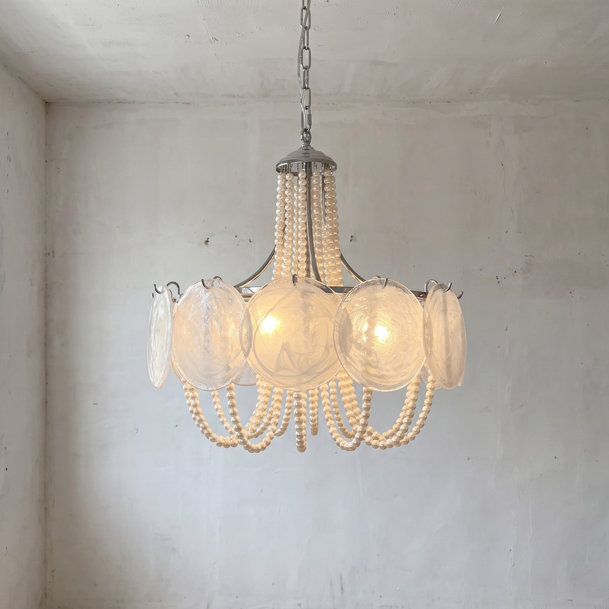 Lustre style Murano opalin argenté, vue d'ensemble, illuminant un salon moderne avec élégance et une touche Art Déco raffinée.