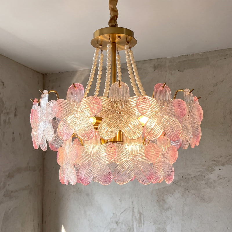 Vue d'ensemble du lustre style Murano, illuminant un salon moderne avec ses délicats pétales de verre rose et transparent.