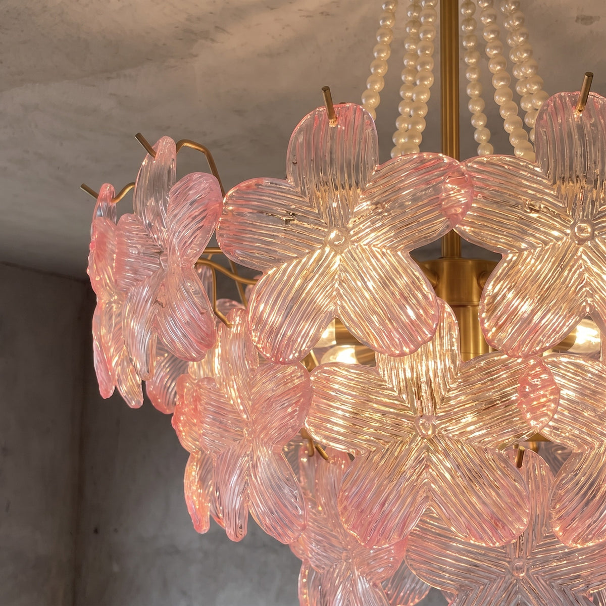 Lustre semi-encastré avec structure dorée et 9 ampoules E14, apportant une touche de luxe floral à une chambre cosy.