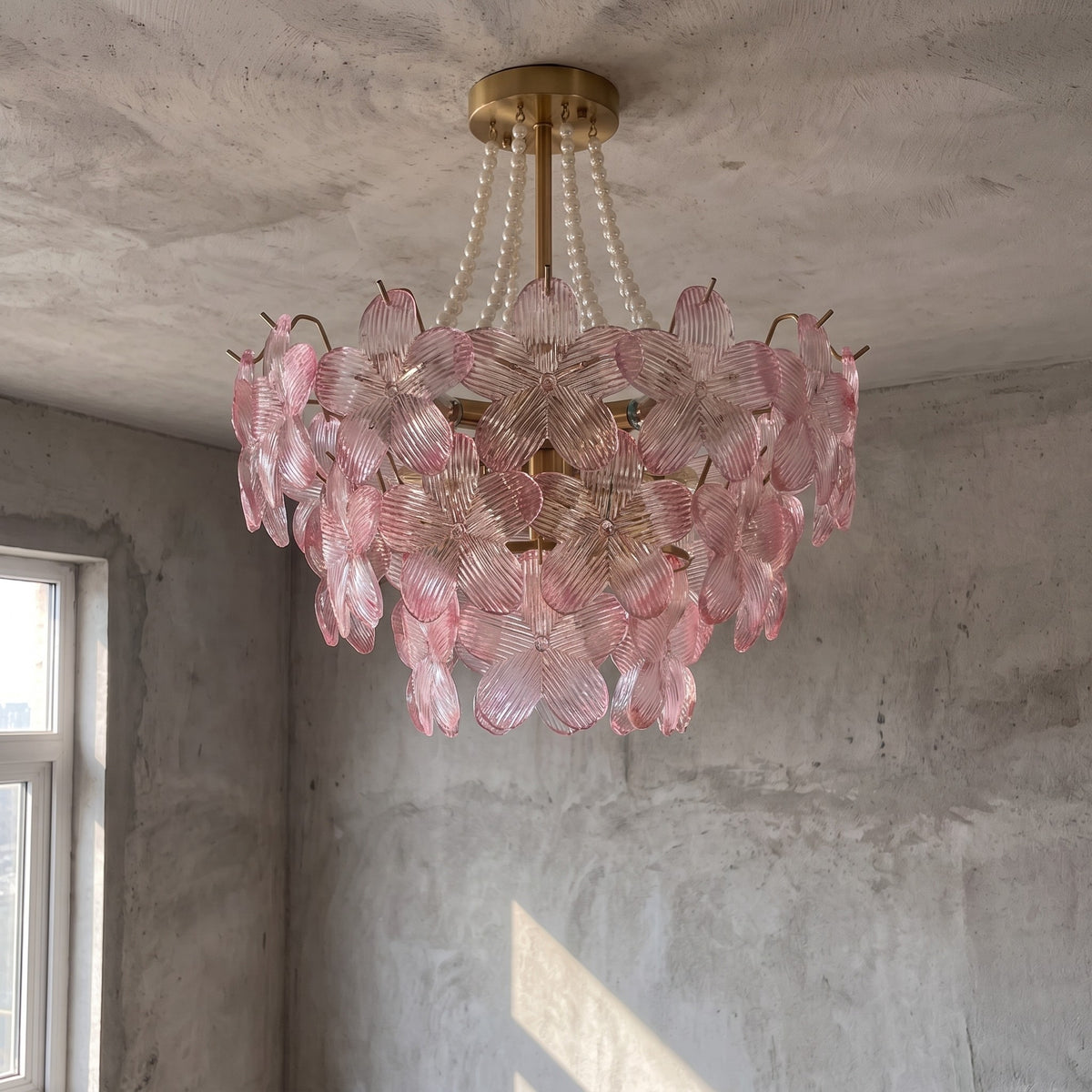 Détail des pétales de verre rose et clair du lustre, montrant la texture délicate et les perles décoratives, un travail raffiné.