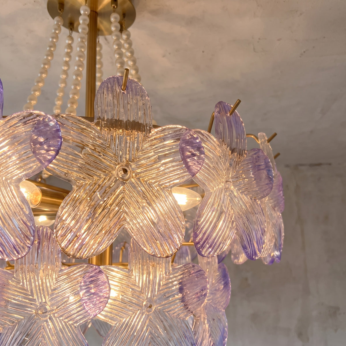 Le lustre semi-plafonnier allumé, révélant le jeu de lumière chaleureuse diffusée par les 6 ampoules E14 à travers le verre.