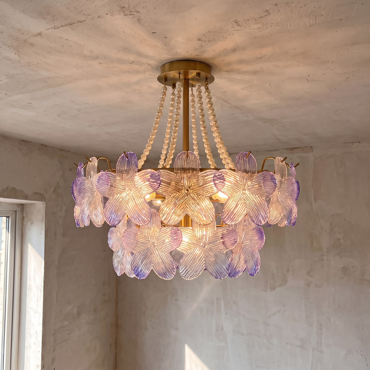 Installation au plafond du lustre, avec sa base de fixation discrète de 12 cm de diamètre et ses chaînes de perles décoratives.