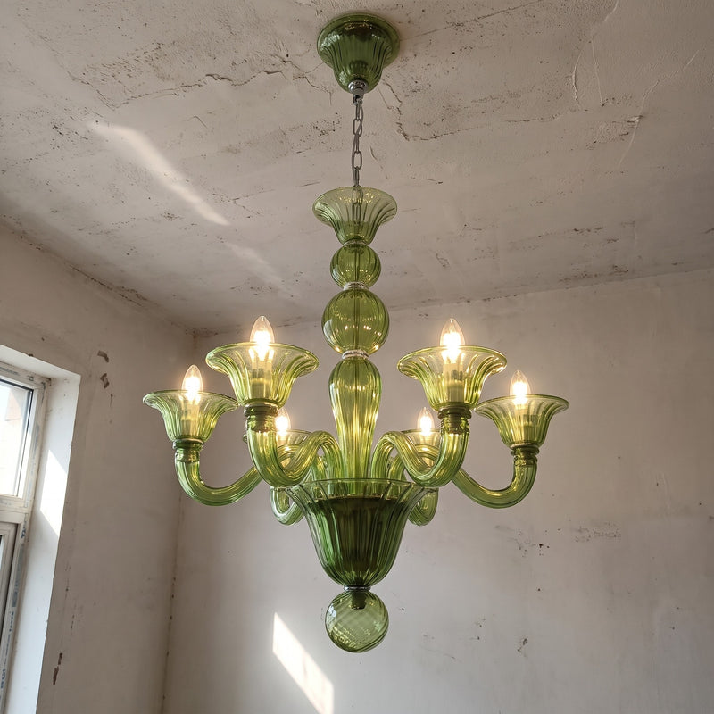 Vue d'ensemble du lustre suspension style Murano vert émeraude, éclairant un grand salon avec sa lumière douce et invitante.
