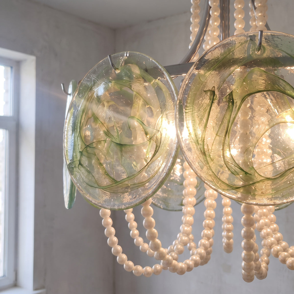 Vue d'ensemble du lustre Murano vert irisé, avec ses perles délicates et sa structure chromée. Idéal pour salle à manger.