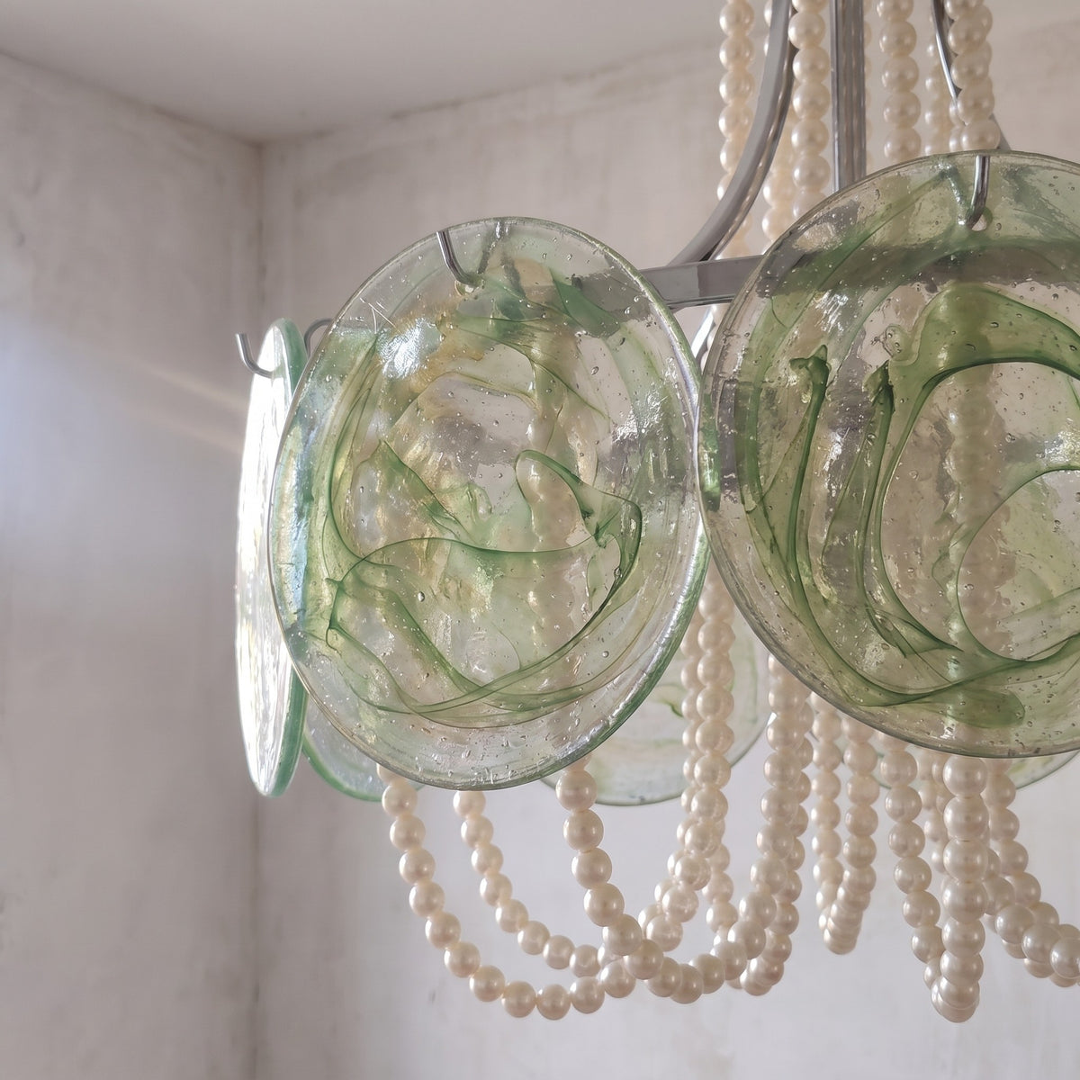 Le lustre suspension Murano allumé, mettant en valeur la brillance des perles et la couleur du verre. Ambiance raffinée.
