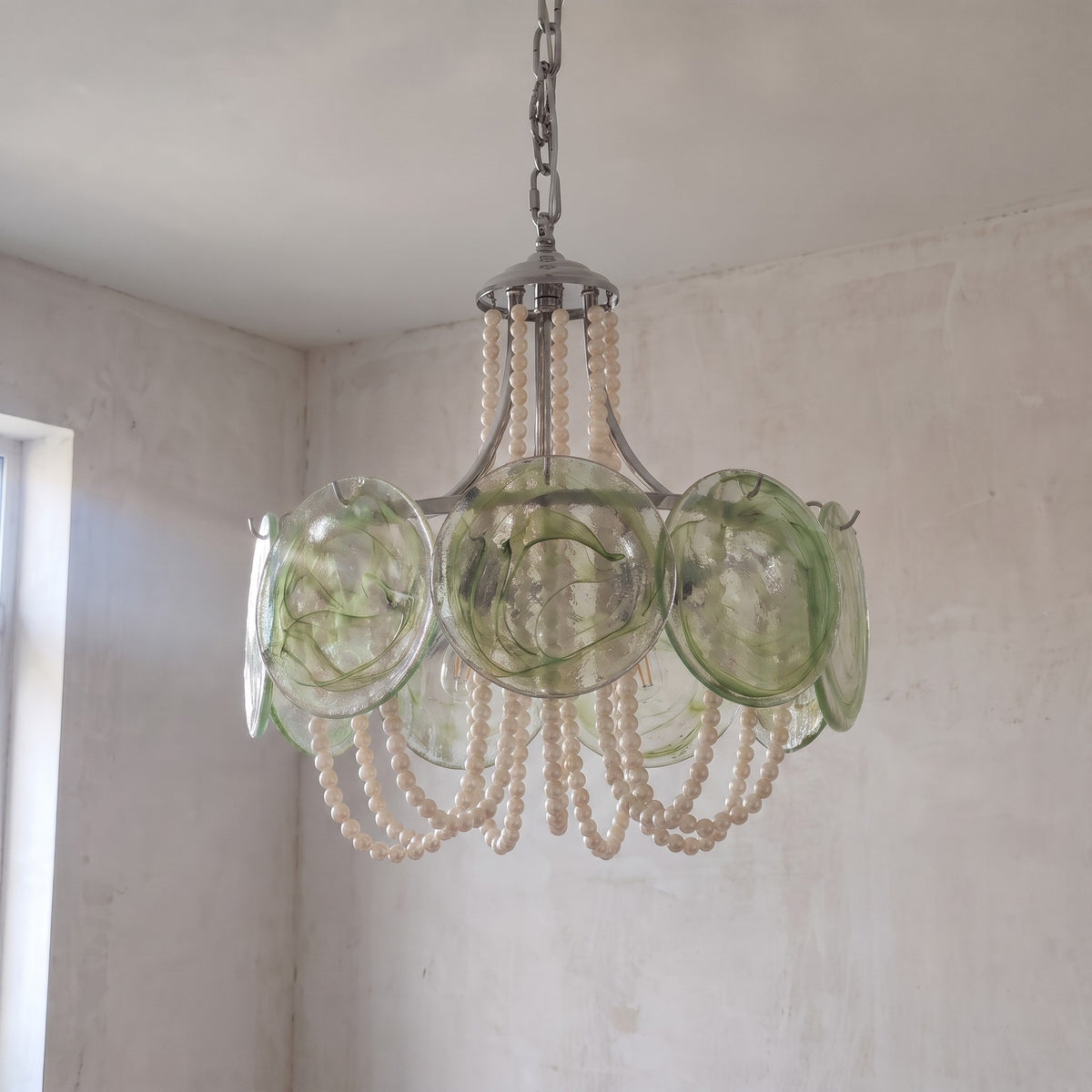 Lustre rond style Murano avec ses chaînes de perles blanches, parfait pour une chambre à coucher ou un hall d'hôtel. Design intemporel.