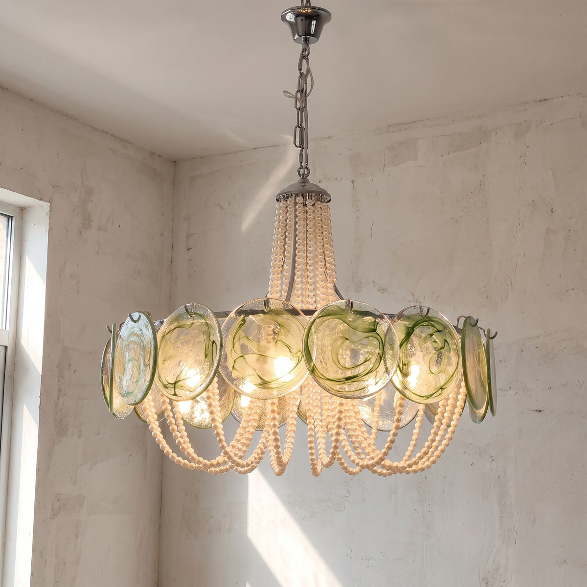 Vue d'ensemble du lustre style Murano vert pâle et crème nacré, éclairant un salon moderne avec une lumière douce et accueillante.