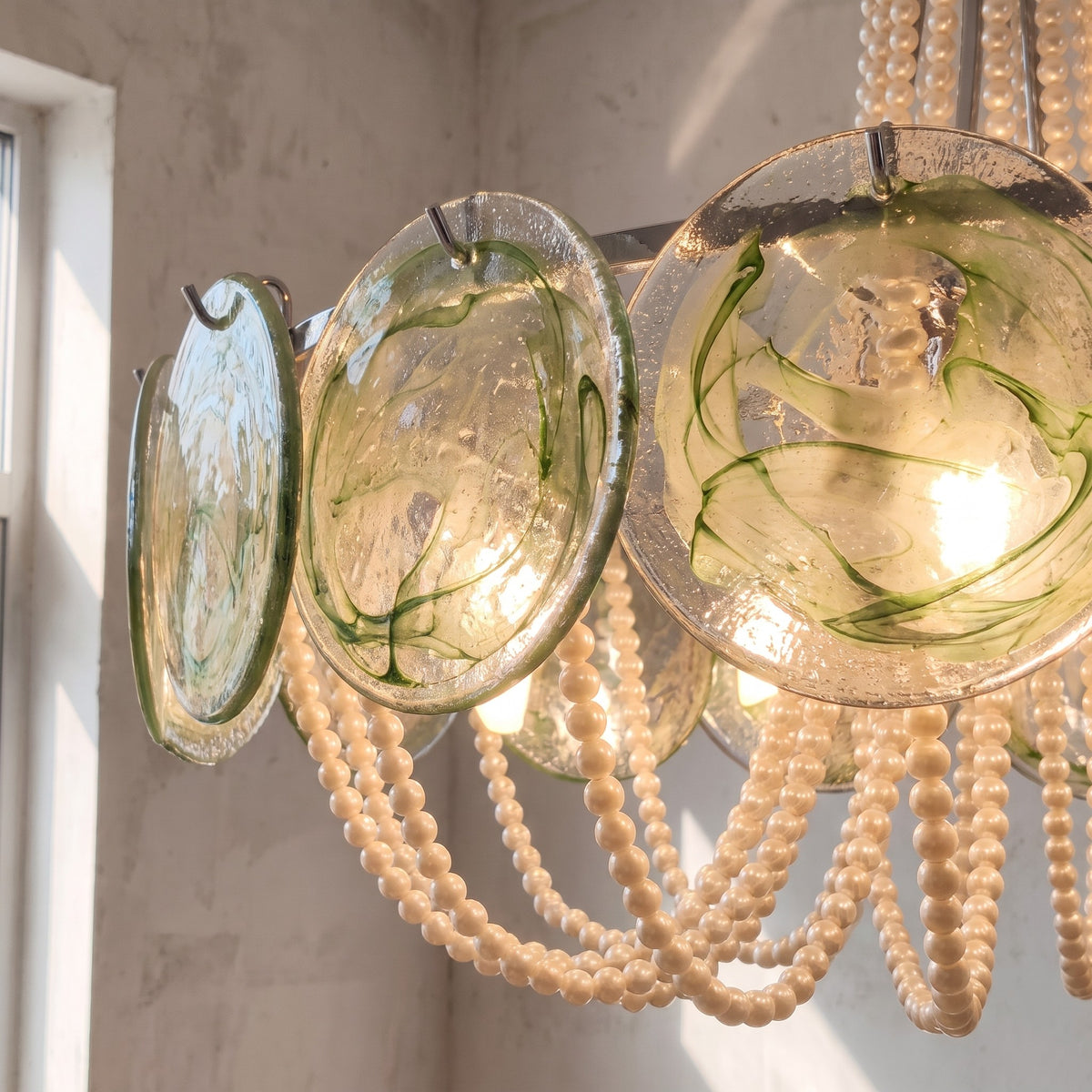 Lustre rond Art Déco avec ses cascades de perles crème nacré, apportant une touche vintage et élégante à une salle à manger spacieuse.