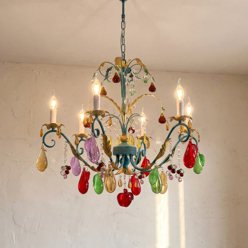 Vue d'ensemble du lustre style Murano vintage bleu-vert, ses six lumières et pendeloques en verre multicolore, illuminant un salon moderne.