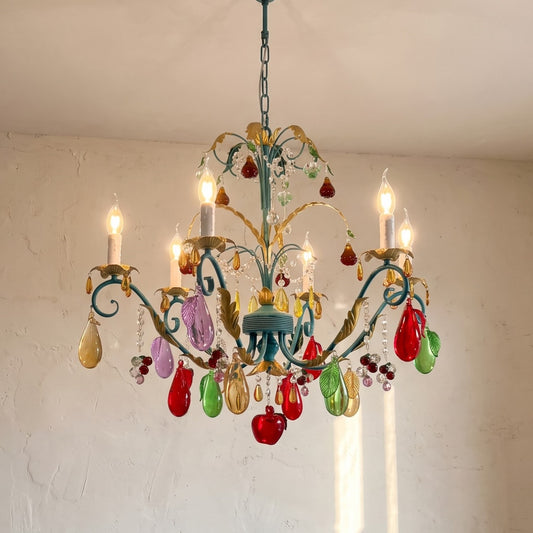 Vue d'ensemble du lustre style Murano vintage bleu-vert, ses six lumières et pendeloques en verre multicolore, illuminant un salon moderne.