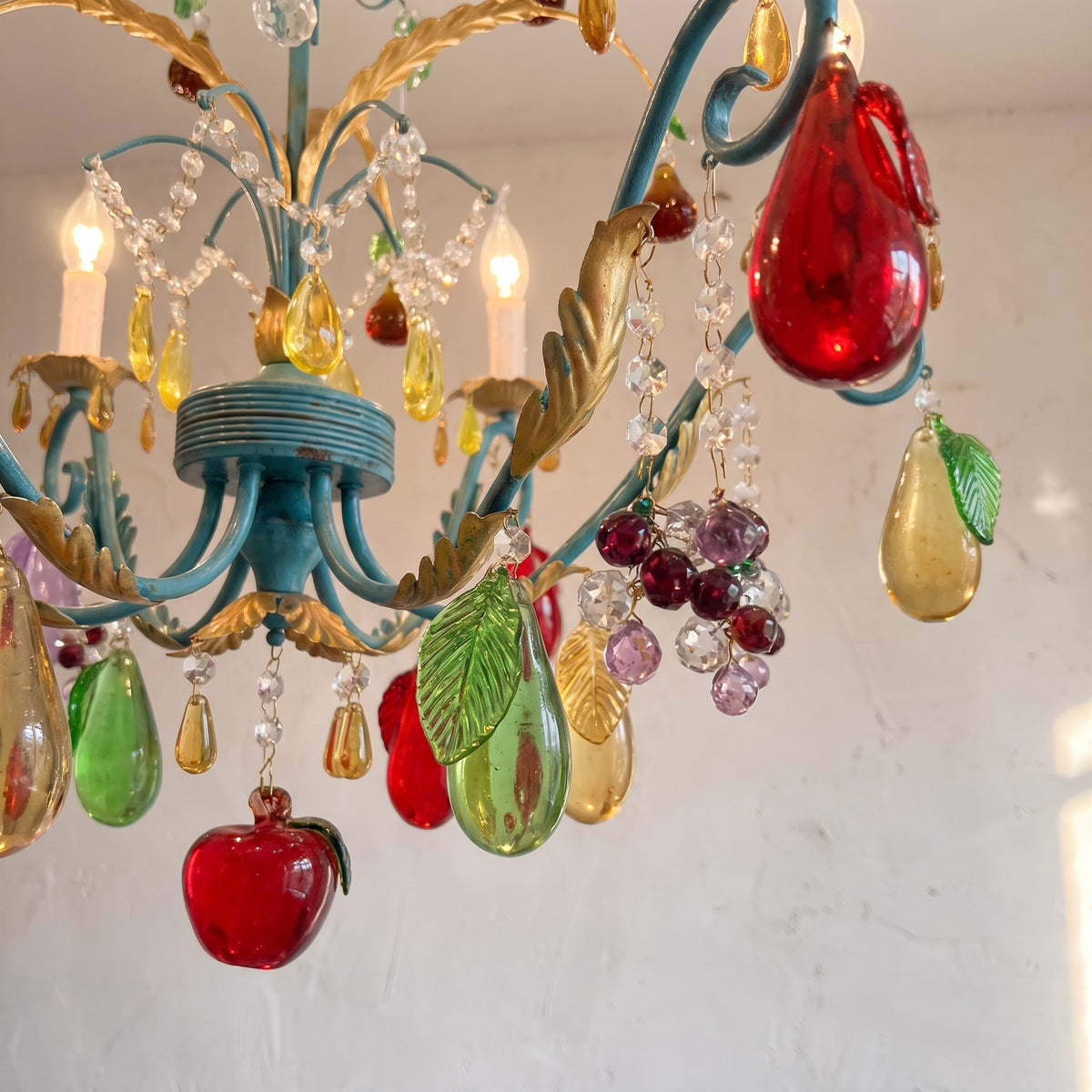 Lustre vintage style Murano allumé, diffusant une lumière chaude et accueillante, avec ses ampoules LED type bougie et son cadre orné.