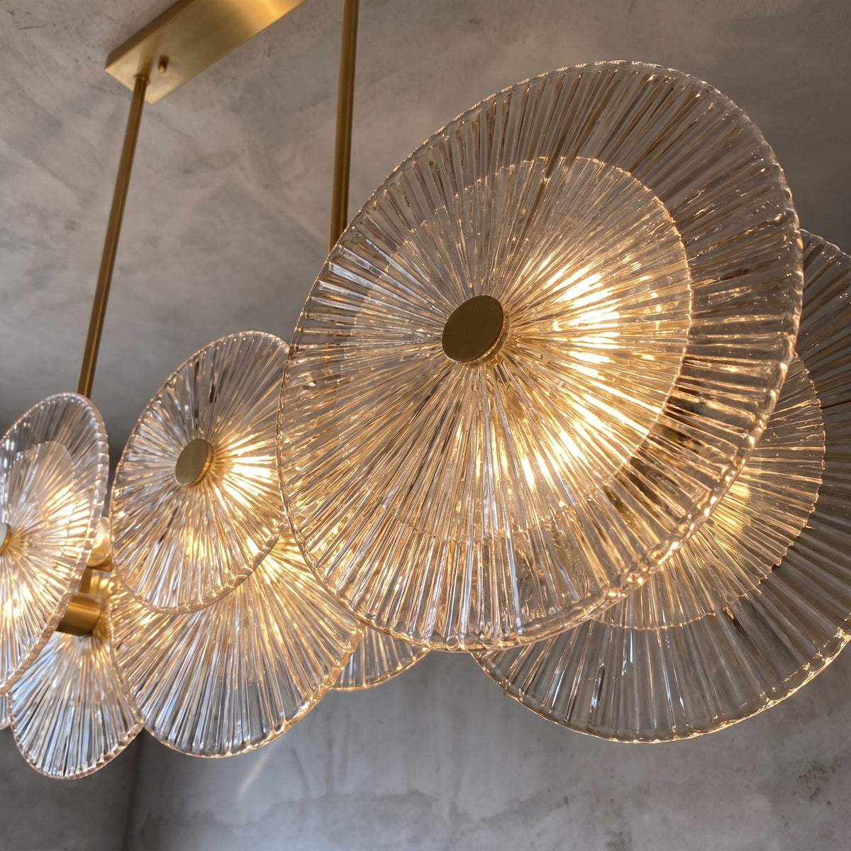 Vue d'ensemble du lustre Murano moderne montrant ses 8 éléments de verre strié et sa structure en acier inoxydable doré.