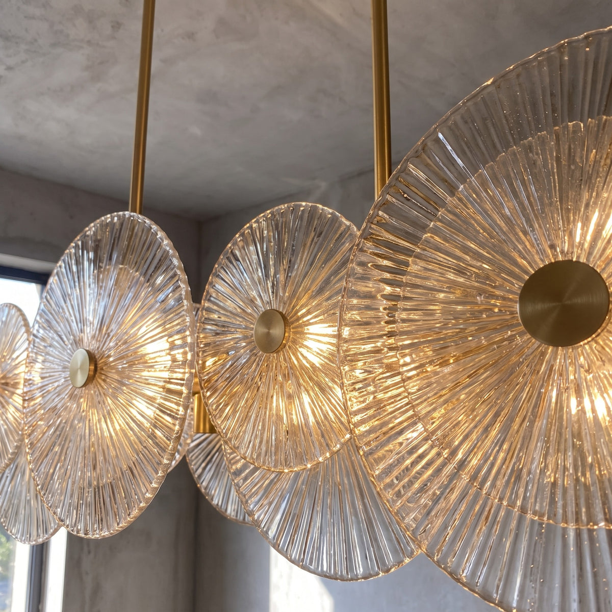 Détail rapproché des disques de verre strié du lustre, révélant la texture artisanale et le jeu de lumière captivant.