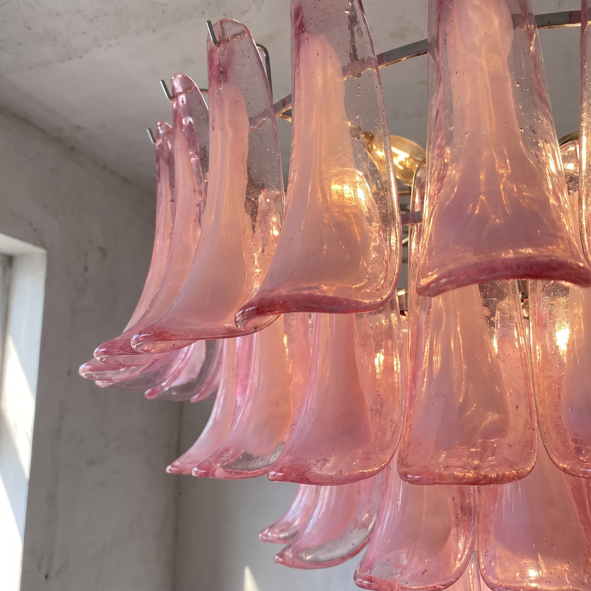 Lustre suspension grand format (80x68cm) en verre rose, design Art Déco, suspendu au plafond d'une pièce avec élégance et raffinement.