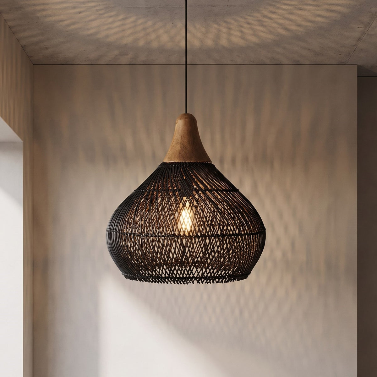 Lustre suspension design artisanal en rotin tressé noir et bois naturel, parfait pour une ambiance sereine dans votre salon.
