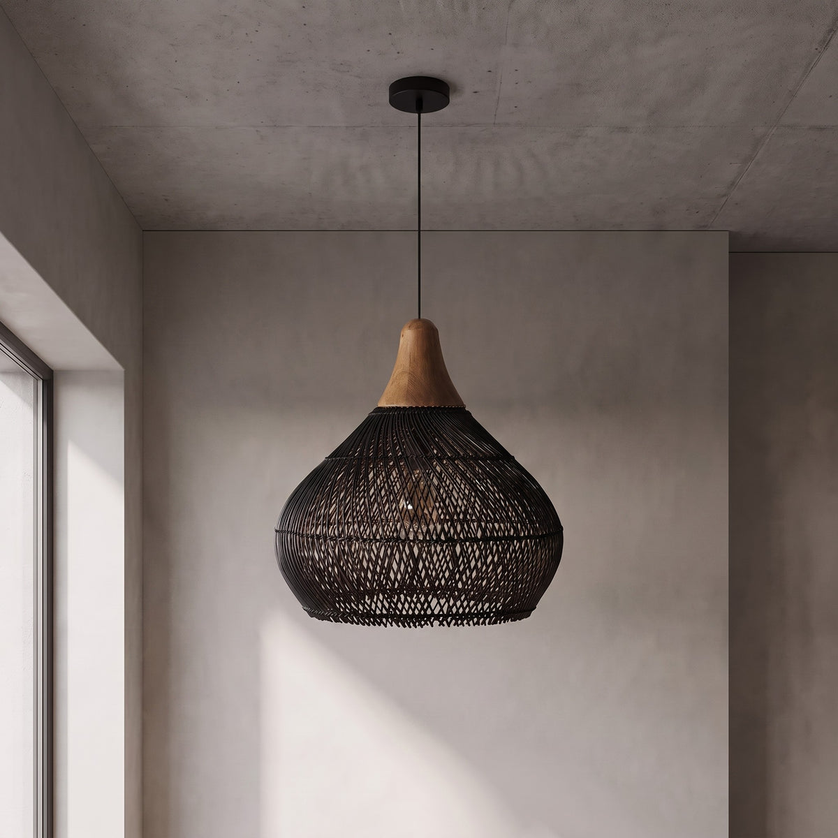 Abat-jour de suspension en rotin noir, révélant la texture unique du tressage, idéal pour un éclairage doux et chaleureux.