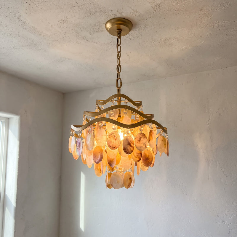 Lustre suspension style vénitien, avec ses coquilles nacrées et sa structure dorée, illuminant un salon élégant.