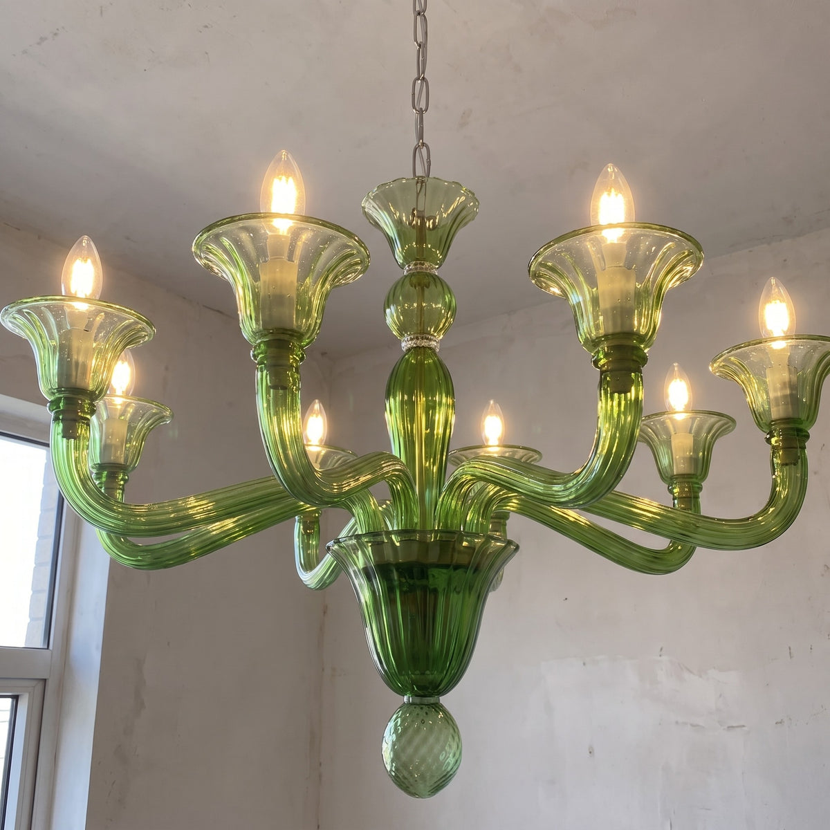 Gros plan sur les détails en verre vert soufflé du lustre style Murano, mettant en valeur la finesse de l'artisanat du verre.